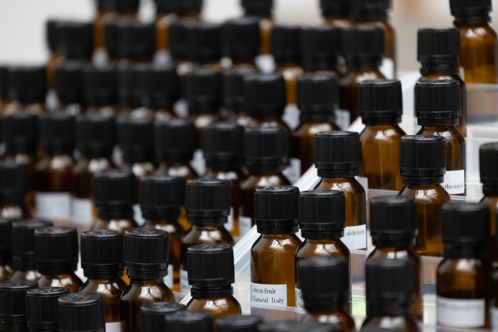 Rows of amber essential oil bottles with handwritten labels