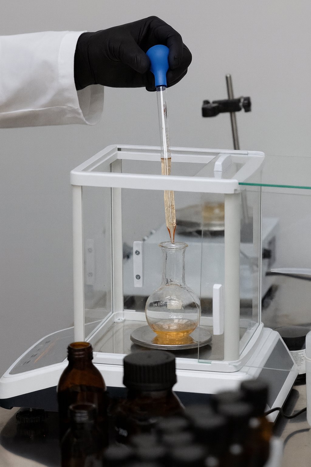 Gloved hand pipetting fragrance formula in the laboratory